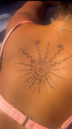 the back of a woman's body with an intricate tattoo design on her stomach