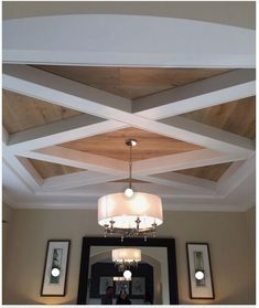 a mirror and light fixture in a room with wood paneling on the ceiling above it