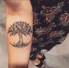 a woman's arm with a tree tattoo on it