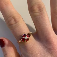 a woman's hand with a ring on it that has two different colored stones