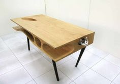 a cat hiding under a wooden table with holes in the top and bottom, on white tile flooring