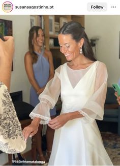 a woman in a white dress standing next to two other women