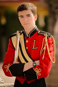 a young man in a red uniform holding a pipe