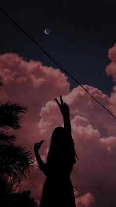 a woman reaching up to the sky with her hand in the air and clouds behind her