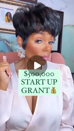 a woman with short black hair holding up a sign that says $ 500, 000 start up grant