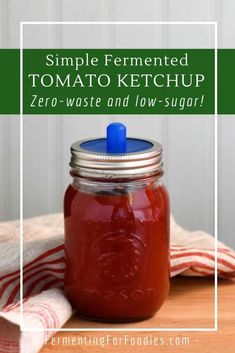 a jar filled with tomato ketchup sitting on top of a wooden table