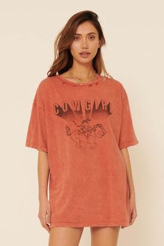 Distressed, mineral washed graphic t-shirt. Vintage-style cowgirl graphic print with "Cowgirl" text. Torn and distressed detailing at neckline, cuffs, and hem. Round neckline. Short sleeves. Drop shoulder. Loose, oversized fit. 100% Cotton. Imported top designed and printed in LA. Model wears size S. Western Style Washed Cotton Tops, Vintage Stonewashed Tops For Fall, Oversized Stonewashed Graphic Tee, Oversized Vintage Stonewashed T-shirt, Western Style Washed Tops With Relaxed Fit, Western Style Washed Top With Relaxed Fit, Casual Distressed Tops For Rodeo, Acid Wash T-shirt With Frayed Hem And Relaxed Fit, Western Style Washed Tops For Spring