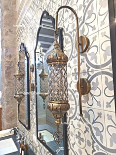 an ornately decorated bathroom with gold fixtures and mirrors on the wall, next to a sink