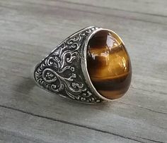 tigers eye ring Sterling silver  Detailed Vintage style  wedding or dress ring with beautiful sc It is made from solid sterling silver (925)\ Solid not hollowed out in the back Avaliable in many stones ( last picture)\ Brown tigers eye Stone measures 16mm x12mm (6/8 ''x 4/8'' approx.) I will rub over set the stones once sold Please note that none of the stones have been set in the photos It weights 12.2 gms approx It is 21mm (7/8 '' wide) It tapers to 3.5mmat the back  I can make this any size Antique Brown Ring Jewelry, Handmade Brown Ring For Wedding, Ornate Handmade Antique Silver Rings, Handmade Ornate Antique Silver Rings, Antique Brown Wedding Rings, Vintage Brown Jewelry Stamped 925, Bohemian Carved Wedding Ring, Wedding Ring Stone, Silver Wedding Ring