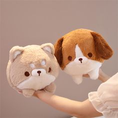 a person holding two stuffed animals in their hands, one is brown and the other is white