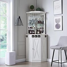 a room with a chair, bar and pictures on the wall above it that is decorated in white