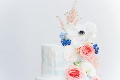 a white cake with pink and blue flowers on top