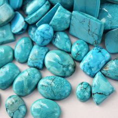 turquoise stones are scattered on a white surface