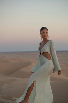 The KEHLANI CUT-OUT DRESS is a floor-length dress designed with a plunging-v neckline and elegant side cut-outs that shape your figure and are fastened at the center with a bamboo ring to flatter. Kehlani features full-length bell sleeves and knee-high slits on either side, and is cut from our viscose crinkle crepe fab Desert Outfit, White Sands New Mexico, Desert Photoshoot, Kehlani, Floor Length Dresses, Sand Dunes, In The Desert, Fashion Photoshoot, Crepe Fabric