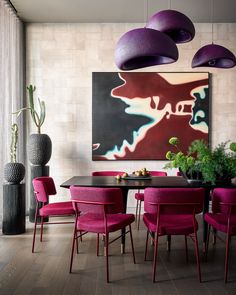 a dining room with purple chairs and a large painting on the wall above it's table