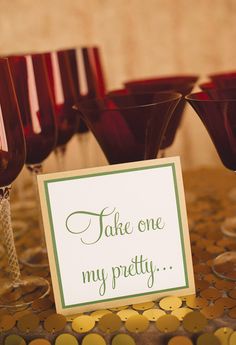 there are wine glasses on the table with a sign in front of them that says take one my pretty