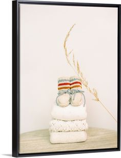 a stack of folded towels sitting on top of a wooden table next to a plant