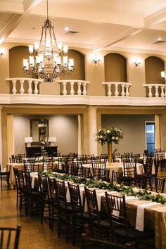 a banquet hall with tables and chairs set up for an event or function in front of chandeliers