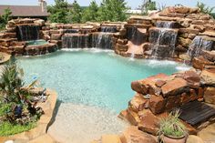 an outdoor pool with waterfall and seating area