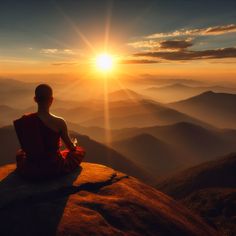 a person sitting on top of a mountain at sunset