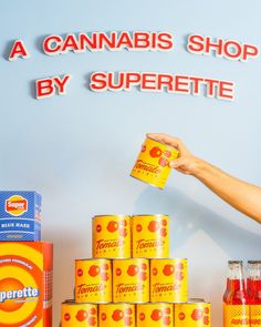 a man holding up a can in front of a display of canned foods and condiments