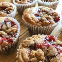 several muffins with crumbs and toppings sitting on a cooling rack