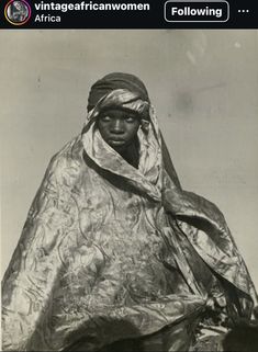 an old black and white photo of a woman wrapped in a silver cloth with the caption vintage african women following africa