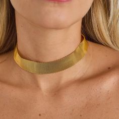 The Gold-Plated Mesh Choker is a piece that blends modern style with a classic touch. Crafted from smooth mesh chain, it offers a sleek texture and an elegant design. The choker's structure is made from noble metal and is gold-plated, providing a luxurious and radiant finish. With a length of 32 cm, this choker is a versatile option to elegantly highlight the neck. The minimalist design of the smooth mesh adds a contemporary touch, while the gold plating lends a classic charm to the piece. This choker is perfect for wearing alone, creating an elegant focal point in your outfit, or layered with other necklaces for a customized style. Its versatility allows it to be worn on various occasions, adding a touch of glamour and sophistication to any look. In summary, the Gold-Plated Mesh Choker is Elegant Jewelry, Earring Necklace, Ring Necklace, Gold Plating, Focal Point, Jewelry Pieces, Elegant Design, Minimalist Design, Modern Style