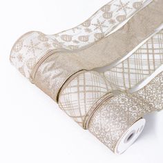 two rolls of white and gold ribbon with snowflakes on them