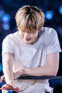 a young man with his arms crossed on stage