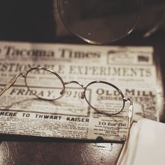 a pair of glasses sitting on top of a newspaper