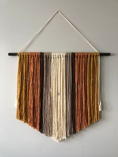 a wall hanging with several different colors of yarn