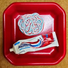 two toothpaste tubes on a red tray