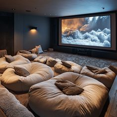 a large room with several bean bags on the floor and a screen in the wall