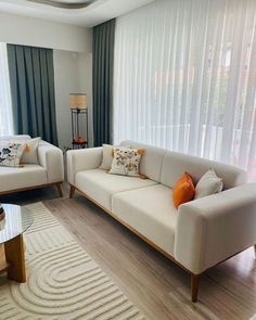 a living room with two couches and a coffee table in front of the window