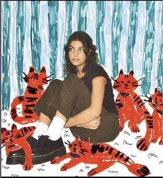 a woman sitting on the ground with her legs crossed in front of many red cats