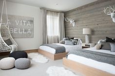 two beds in a room with white carpet and wooden walls, one bed is made up