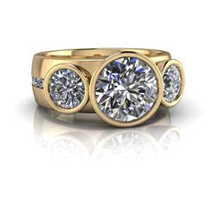 three stone diamond ring in yellow gold with diamonds around the band and side stones on either side