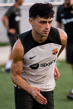 a young man holding a soccer ball on top of a field