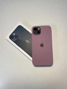 two iphones sitting next to each other on top of a white table with an apple logo