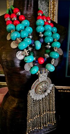 Here's a very bold, chunky and heavy tribal - ethnic chest piece that is not for the faint of heart!! Red, blue and green magnesite beads form the bulk of this piece along with a few carved emerald and sapphire beads. Silver tone stamped tribal bi-cones and vintage Kuchi coins are also featured which give additional drama and interest. A huge architectural Waziri pendant with inlaid glass is the focal point on this piece and measures 9" x 4". The innermost strand adjusts from 23-25" and I can add more chain links, if requested. Closes with an xl fancy gunmetal toned lobster claw clasp. From the Atelier of Kat Kouture! (This is quite heavy so please know your tolerance before you purchase). Artisan Turquoise Necklace With Large Beads For Festival, Traditional Multicolor Turquoise Necklace With Large Beads, Traditional Turquoise Necklace With Natural Stones For Festivals, Bohemian Turquoise Beaded Necklaces For Festive Occasions, Bohemian Style Turquoise Beaded Necklace For Festive Occasions, Artisan Turquoise Necklace For Festivals, Traditional Turquoise Necklace For Festivals, Traditional Blue Turquoise Necklace For Festivals, Handmade Traditional Turquoise Necklace For Festivals