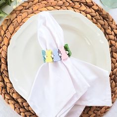 the napkins are folded on top of each other near a plate with flowers in it