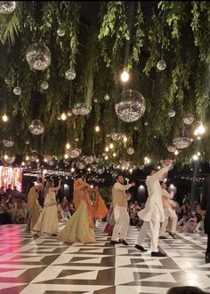 several people are dancing on a checkered floor with chandeliers hanging from the ceiling