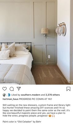 a bed room with a neatly made bed next to a white wall and two lamps