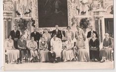 an old black and white photo of people in front of a portrait on a wall