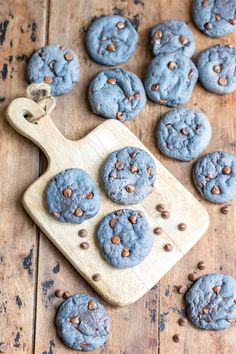 chocolate chip cookies sitting on top of a wooden cutting board