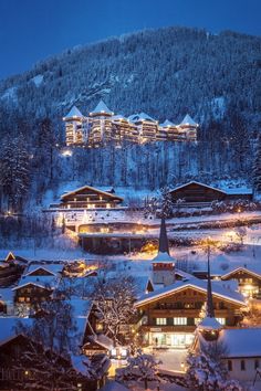 the town is lit up at night in the mountains