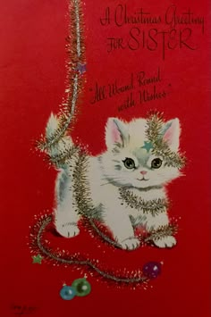 a christmas card with a white kitten on it's back and the words, a christmas greeting for sister