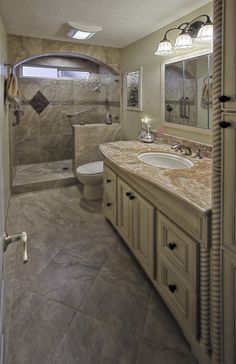 a large bathroom with marble counter tops and tile flooring, along with a walk in shower