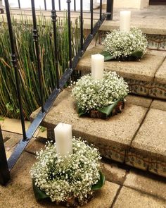 three candles are sitting on some concrete steps